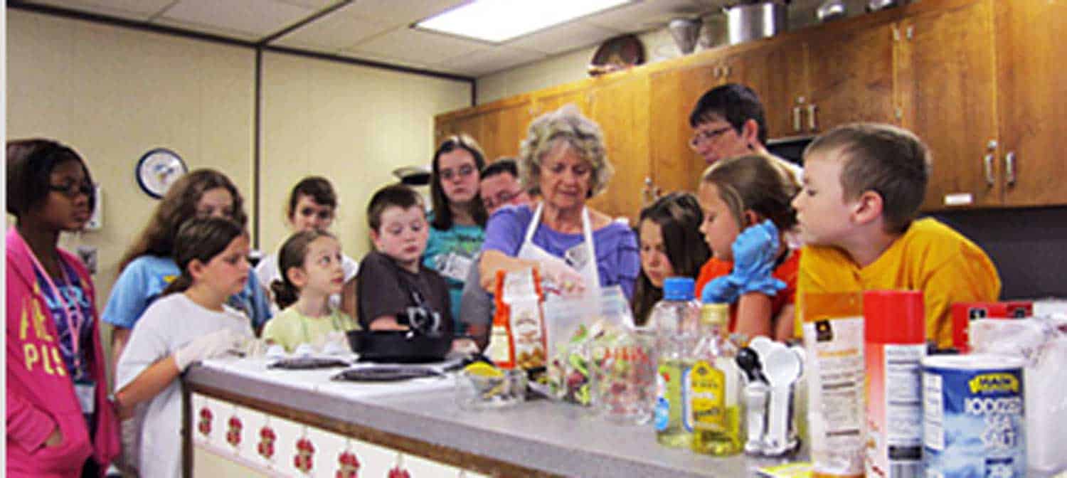 Teacher showing kids how to cook