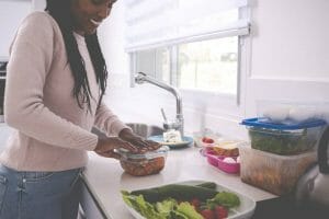 woman washing vegetables in kitchen